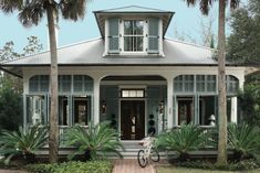 a house with palm trees in front of it and a door on the other side