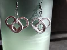 the earrings are shaped like two interlocked hearts