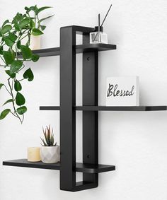 two black shelves with plants on them and a sign that says bespal next to it