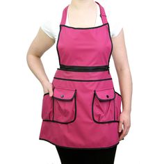 a woman wearing a pink apron with black trim and pockets on the front, standing in front of a white background