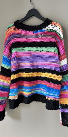 a multicolored sweater hanging on a hanger