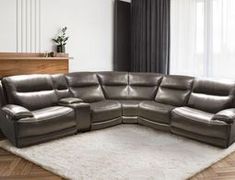 a living room with a large sectional couch and white rug on top of the floor