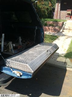 the back end of a blue truck with its trunk open and it's hood up