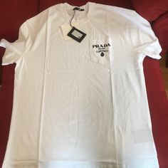 Prada White Tee-Shirt With Print On Pocket. Size 2xl. New. Authentic. Never Worn. See Photos. Luxury Tops With Pockets, Luxury White Cotton Shirt, Luxury White Summer Shirt, Prada Shirt, Pocket Tees, White Tee Shirts, White Tee, Pocket Tee, Pocket Size