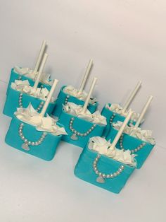 there are six toothbrush holders with pearls on the top and one is decorated in blue