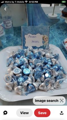 there is a plate full of blue and white candies on the table with a card