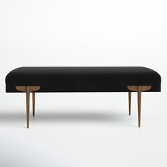 an upholstered bench with wooden legs and a black fabric cover on the top