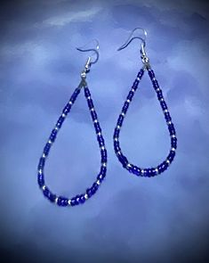 "These beautiful 2 3/4\" earrings are made with blue and purple and silver seed beads. These beads are a nice embellishment to the classic teardrop hoop earrings. These teardrop earrings are very comfortable because they are so lightweight.  Hoop earrings are classic, and these are teardrop hoops, with a pattern that makes a statement. You can't go wrong with these earrings! They are great all year round. They come in a box for easy gift giving too. They are a great birthday, Mother's Day, or Christmas gift! 1006" Blue Silver Beads Drop Earrings, Blue Silver Beaded Drop Earrings, Adjustable Blue Beaded Earrings With Silver Beads, Blue Drop Earrings With Silver Beads, Purple Teardrop Earrings With Dangling Beads, Adjustable Blue Teardrop Hoop Earrings, Silver Beaded Teardrop Earrings As Gift, Silver Beaded Teardrop Earrings For Gift, Purple Teardrop Beaded Earrings With Dangling Beads