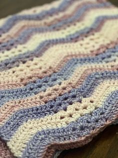 a crocheted blanket sitting on top of a wooden table