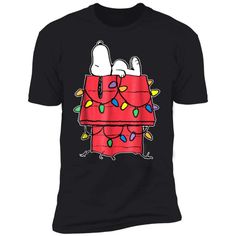 a black shirt with snoopy christmas lights on it's chest and two dogs sitting inside