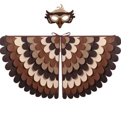 a mask is attached to the wings of an owl's wing with brown and white shapes