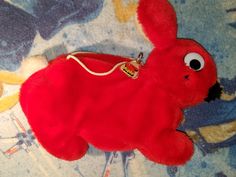 a red stuffed animal laying on top of a bed