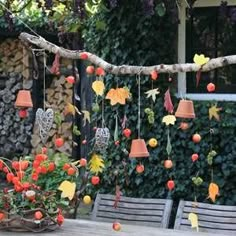 an outdoor table with chairs and flowers hanging from it