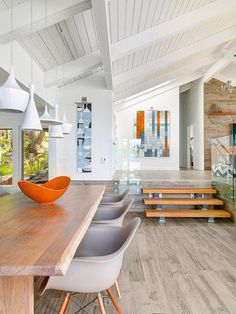 an open concept kitchen and dining room with wood flooring, white walls and ceiling