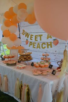 a table topped with lots of desserts and balloons in front of a sign that says sweet as peach