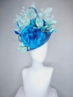 From the 2024 Featured Milliner of the Kentucky Derby Museum  Gorgeous Kentucky Derby hat fascinator  kentucky derby hat fascinator  turquoise blue sinamay saucer with blue silk flowers mint green leaves and mint green feathers headband attachment each hat is totally one of a kind! no two are alike! I can probably add feathers, flowers etc to existing hats for a small fee. I cannot remove anything from existing hats. Just message me and see if we can make it work! :) I cannot make custom order f Blue Mini Hats With Handmade Flowers For Royal Ascot, Blue Fascinator With Handmade Flowers For Kentucky Derby, Blue Fascinator For Royal Ascot Garden Party, Blue Fascinator For Garden Party At Royal Ascot, Blue Fascinator For Garden Party And Royal Ascot, Blue Handmade Flowers Fascinator For Races, Light Blue Headpieces For Royal Ascot, Blue Feather Fascinator For Kentucky Derby, Blue Feathered Fascinator For Kentucky Derby