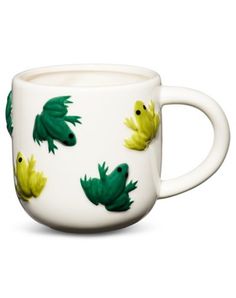 a white coffee cup with green and yellow fish on the inside, in front of a white background