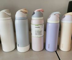 thermos are lined up next to each other in different colors and sizes,