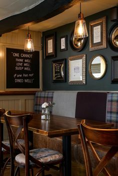 a restaurant with wooden tables and chairs, framed pictures on the wall above each table