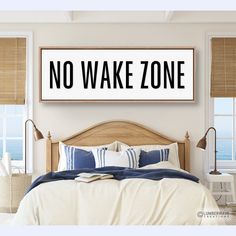 there is a bed with pillows and blankets on it in front of a window that says no wake zone