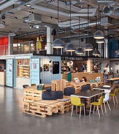 the interior of a restaurant with tables and chairs made out of wooden pallets,