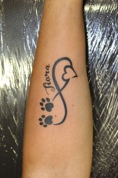 a person with a tattoo on their arm and paw prints in the shape of a heart