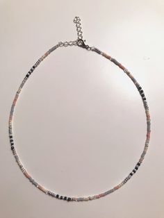 This dainty Seed Bead Choker Necklace is made with pretty multi-colored glass seed beads. The tiny seed beads are strung on beading wire & finished with a silver plated lobster style clasp with a 2 inch extension chain, to allow for personal size adjustments. These necklaces are perfect for everyday wear. Enjoy a simple, boho /chic look with a single strand or layer them with some of our other chokers. * Custom hand-made to order * Glass seed bead size 11/0 * Lobster Clasp closure * Stainles Metal Beaded Necklaces With Spacer Beads, Czech Glass Beaded Chain For Jewelry Making, Handmade Silver Heishi Beads, Gift Beaded Necklace With Silver Beads, Dainty Crystal Necklaces For Jewelry Making With Colorful Beads, Dainty Necklace With Round Beads, Silver Heishi Beaded Bracelets With Tiny Beads, Silver Heishi Bead Bracelet With Tiny Beads, Silver Heishi Spacer Beads