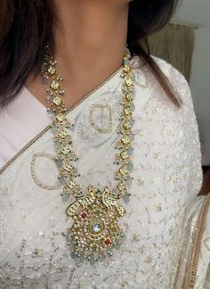 "Discover our Long Kundan Necklace Set, featuring Mint Green Beads, Ruby accents, and multicolored stones for a vibrant look. This exquisite Jaipur Jewelry piece is perfect for Pakistani bridal and Indian wedding celebrations, blending traditional craftsmanship with contemporary elegance. Elevate your style with this stunning long necklace set, ideal for any special occasion." Our products are meticulously handcrafted, ensuring each piece is unique. Due to the manual craftsmanship, you may notic Silver Temple Necklace With Peacock Design For Wedding, Multicolor Bridal Necklace With Peacock Design For Celebration, Multicolor Beaded Necklaces For Wedding, Traditional Tilla Mala For Wedding, Traditional Wedding Mala With Tilla, Traditional White Wedding Mala, Silver Kundan Bridal Necklace With Peacock Design, Silver Kundan Necklace With Peacock Design For Wedding, Temple Jewelry Style Mala With Tilla For Wedding