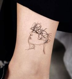 a woman's foot with a tattoo on it that has lines in the shape of a head