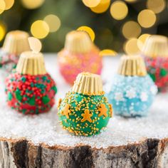 small christmas ornaments sitting on top of a tree stump