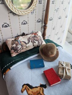 a bed with a hat on top of it next to a pillow and other items