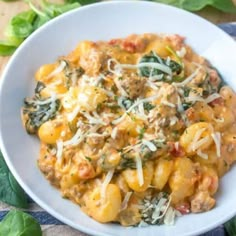 one pot creamy sausage gnocchini with spinach and cheese in a white bowl