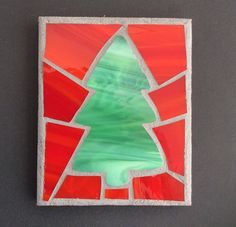 a piece of art that looks like a stained glass window with a christmas tree on it