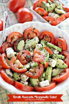 a white bowl filled with cucumber, tomato and feta cheese salad on top of a table