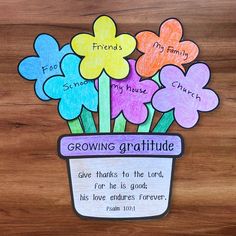 a flower pot filled with flowers on top of a wooden table next to a poem