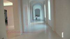 a person walking down a long hallway with white walls