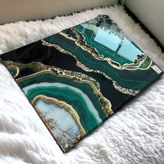 a green and gold marbled tray sitting on top of a white furnishing