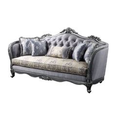 an ornately decorated couch with pillows on it's back and armrests