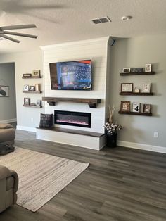 a living room with a large flat screen tv mounted on the wall next to a fireplace