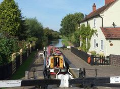 there is a boat that is going down the canal in the city street and houses on either side