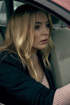 a woman sitting in the drivers seat of a car