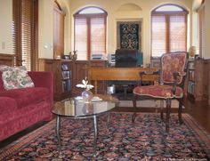 a living room with two red couches and a coffee table in front of it