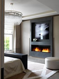 a bedroom with a bed, chandelier and fire place in the fireplace area