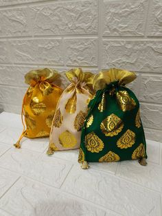 three bags with gold foil designs on them sitting on a table next to each other