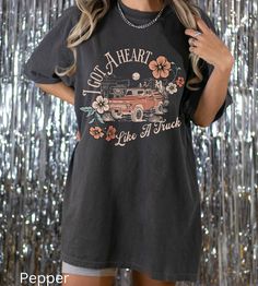 "Comfort Colors I Got A Heart Like A Truck Shirt -UNISEX Comfort Colors C1717 T-SHIRTS -100% ring-spun cotton - Preshrunk, soft-washed, garment-dyed fabric  -Set-in sleeves  -Double-needle stitched sleeves and bottom hem  -Twill taped shoulder-to-shoulder  -1\" ribbed collar with double-needle topstitched neckline Please order 1 or 2 sizes up for an oversized look. These ultra soft pigment dyed shirts are one of our best sellers! I DO NOT ACCEPT EXCHANGES OR RETURNS: all items are made to order. PROCESSING AND SHIPPING 3-5 business days for processing Allow 1-7 business days for shipping Please make sure you put the right address before purchasing!  CARE INSTRUCTIONS Wash inside out with similar colors Tumble dry low or hang to dry Try not to iron Machine wash cold *How to Place an Order* Retro Cotton T-shirt With Heart Graphic, Retro Crew Neck Top With Heart Graphic, Short Sleeve Graphic Tee With Heart Graphic, Heart Graphic Short Sleeve Graphic Tee, Band Merch Crew Neck Top With Heart Graphic, Band Merch Cotton Top With Heart Graphic, Concert Short Sleeve Pre-shrunk Tops, Cotton Band Merch Top With Heart Graphic, Black Band Merch Top With Heart Graphic