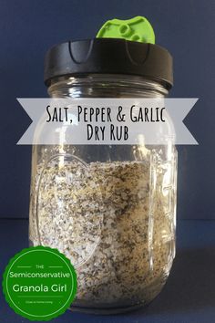 salt, pepper and garlic dry rub in a glass jar with a black lid on a blue background