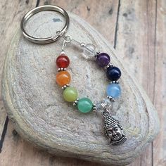 a key chain with seven chakras on it sitting on top of a rock