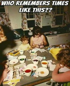 a group of people sitting around a kitchen table with bowls and plates on top of it