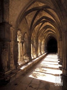 the sun shines through an arched stone building with columns and arches on both sides