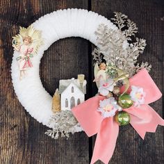 a wreath with an angel decoration on it sitting on a wooden table next to other decorations